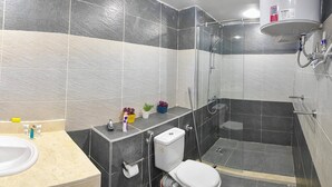 Une salle de bain avec un lavabo, des toilettes et une douche.