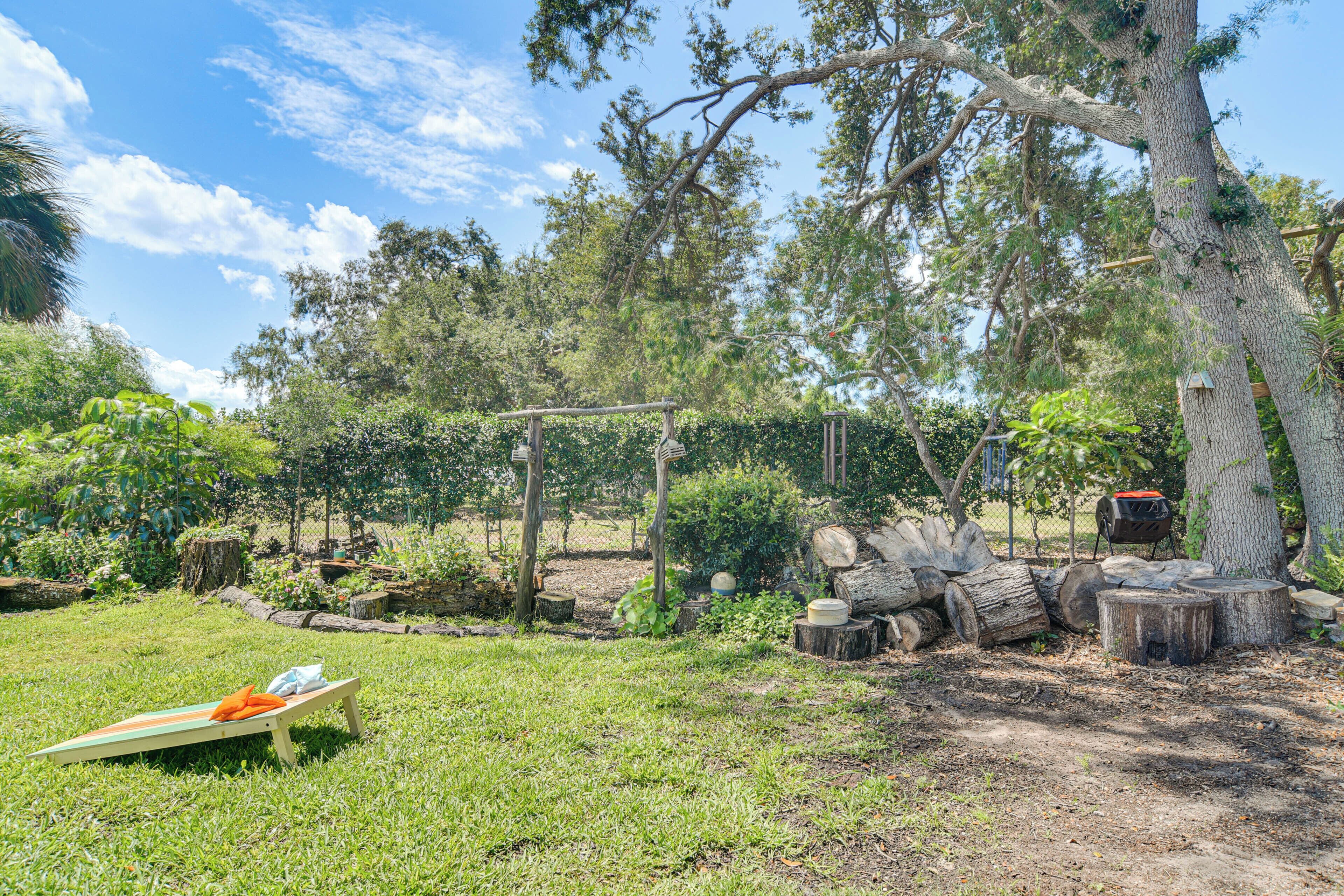 A natural outdoor setting with a wooden bench, logs, and trees.