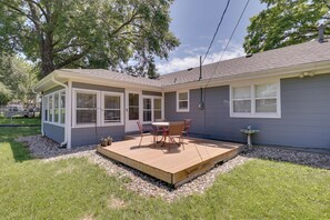 Une maison dotée d’un patio couvert, d’une terrasse et d’un petit jardin.