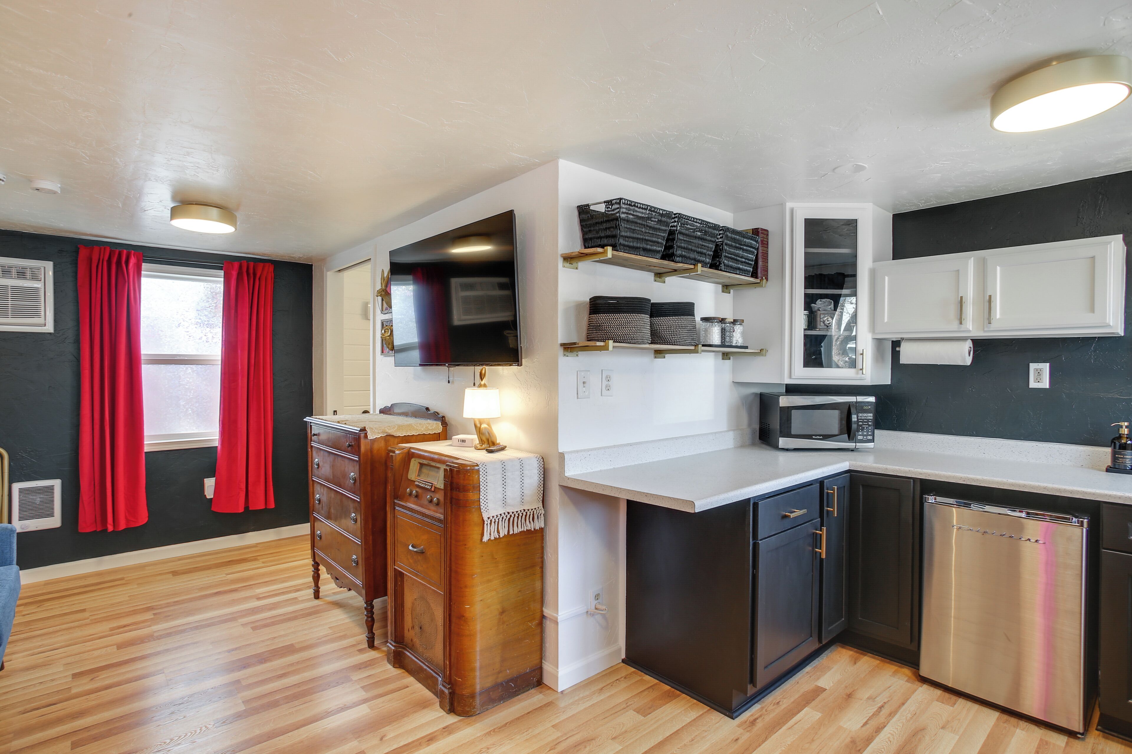 Una cocina compacta con microondas, lavavajillas y armarios de madera.