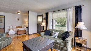 Um quarto com cama, sofá, mesa de centro e duas luminárias.