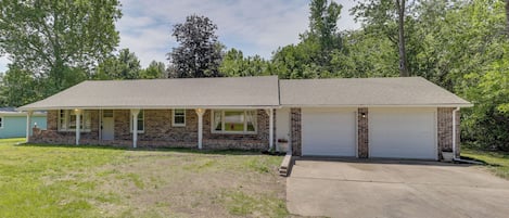 A two-story house with a garage, a covered porch, and a front yard.