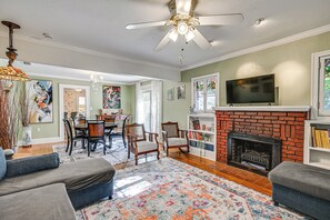 A living room with a fireplace, a television, and a dining area with chairs and a table. - 4 Mi to Dtwn! Tranquil Tampa Getaway w/ 2 Decks (Tampa)