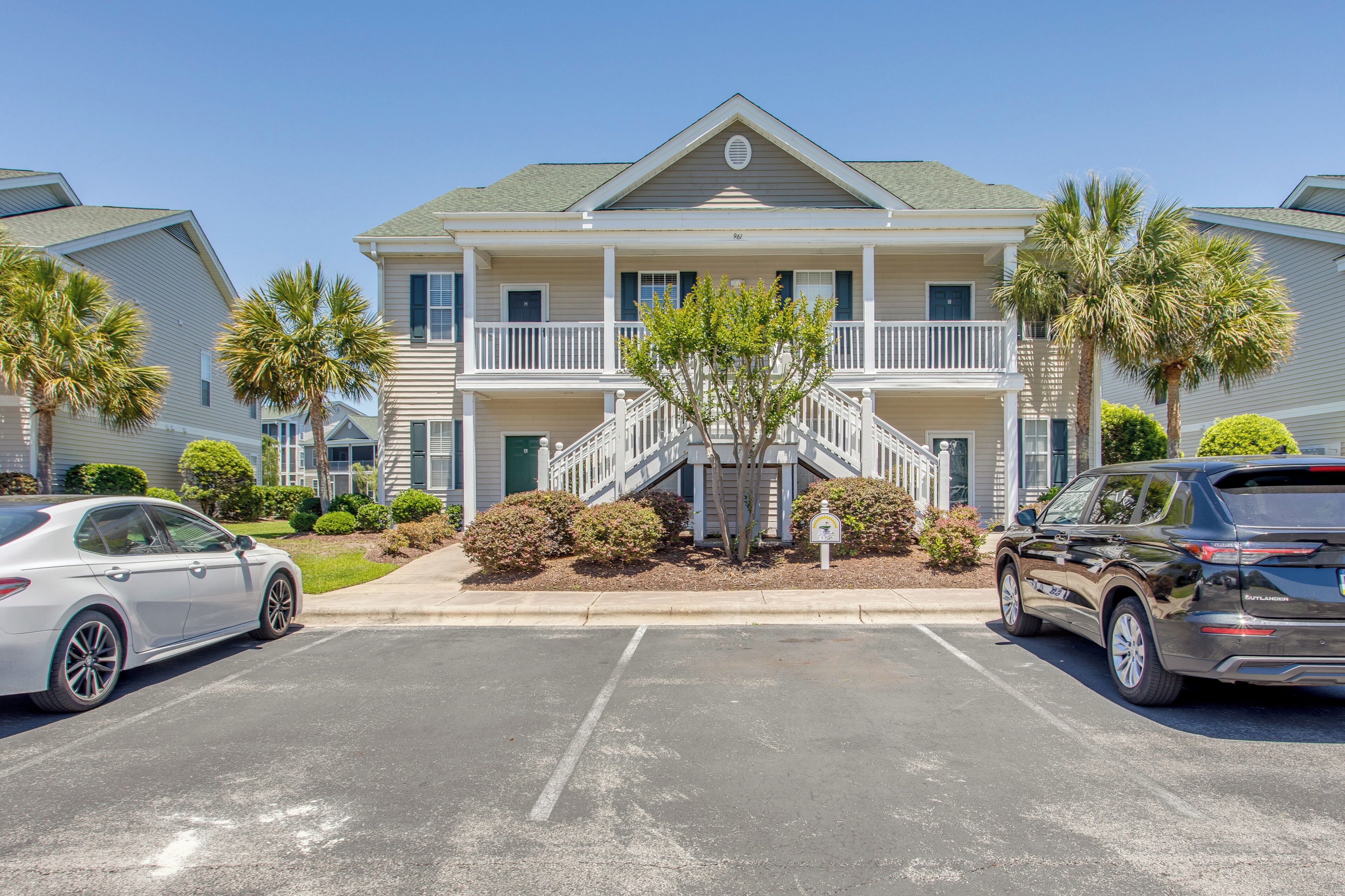 Un bâtiment à deux étages doté d’un balcon, d’un escalier et d’un parking pouvant accueillir deux voitures.