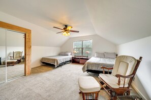 A bedroom with two beds, a rocking chair, a wooden floor, a ceiling fan, and a large window. - Private Patio & Mtn Views: Drake Home on 5 Acres (Drake)