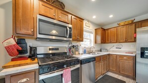 A kitchen with wooden cabinets, a stainless steel microwave, a gas stove, a dishwasher, and a refrigerator. - Private Patio & Mtn Views: Drake Home on 5 Acres (Drake)