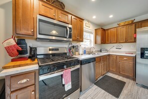 A kitchen with wooden cabinets, a stainless steel microwave, a gas stove, a dishwasher, and a refrigerator. - Private Patio & Mtn Views: Drake Home on 5 Acres (Drake)