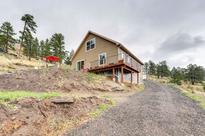A two-story house with a porch, a gravel driveway, and a red umbrella. - Private Patio & Mtn Views: Drake Home on 5 Acres (Drake)