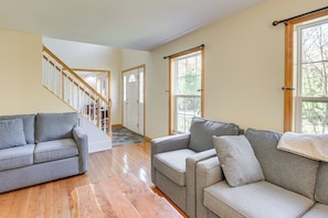 A spacious living room with hardwood floors, a staircase, and large windows. - 4 Mi to Acadia Trails! Coastal Maine Launchpad (Mount Desert)
