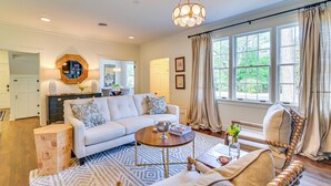 A spacious living room with a sofa, coffee table, and a decorative lamp. - Starkville Estate 1 Mi to Msu: 2-unit Combo! (Starkville)