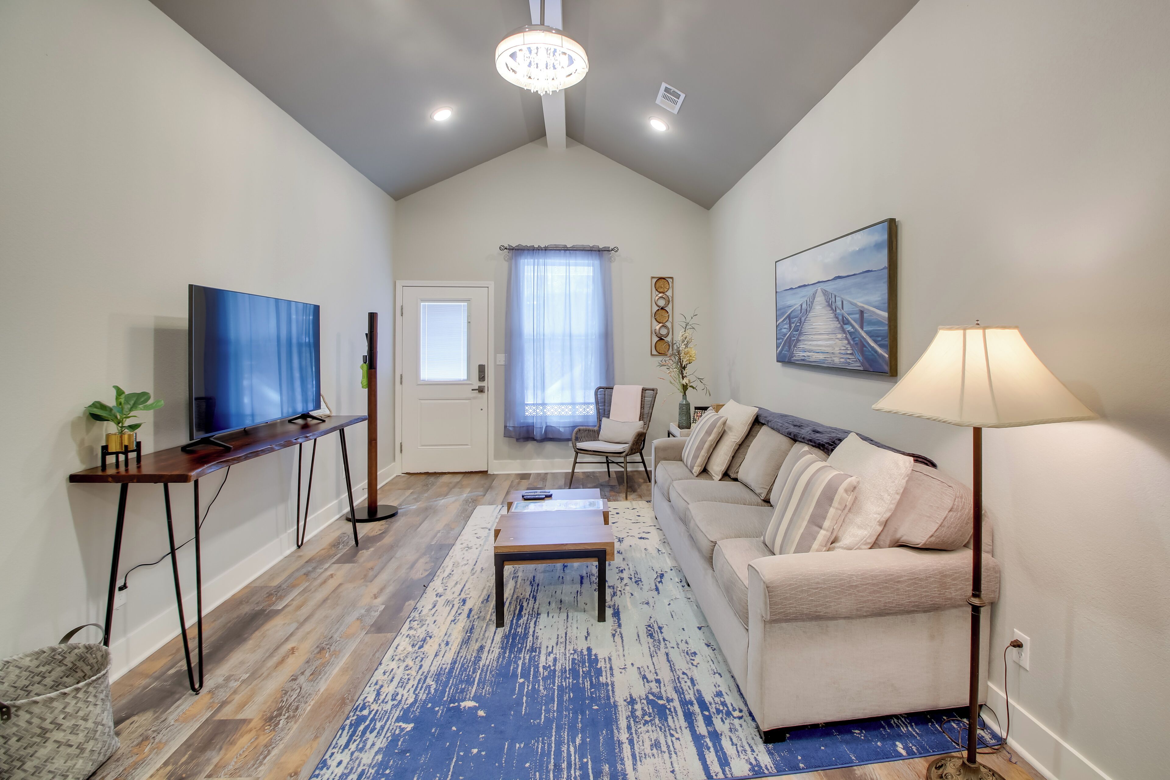 A living room with a television, sofa, coffee table, and lamp.