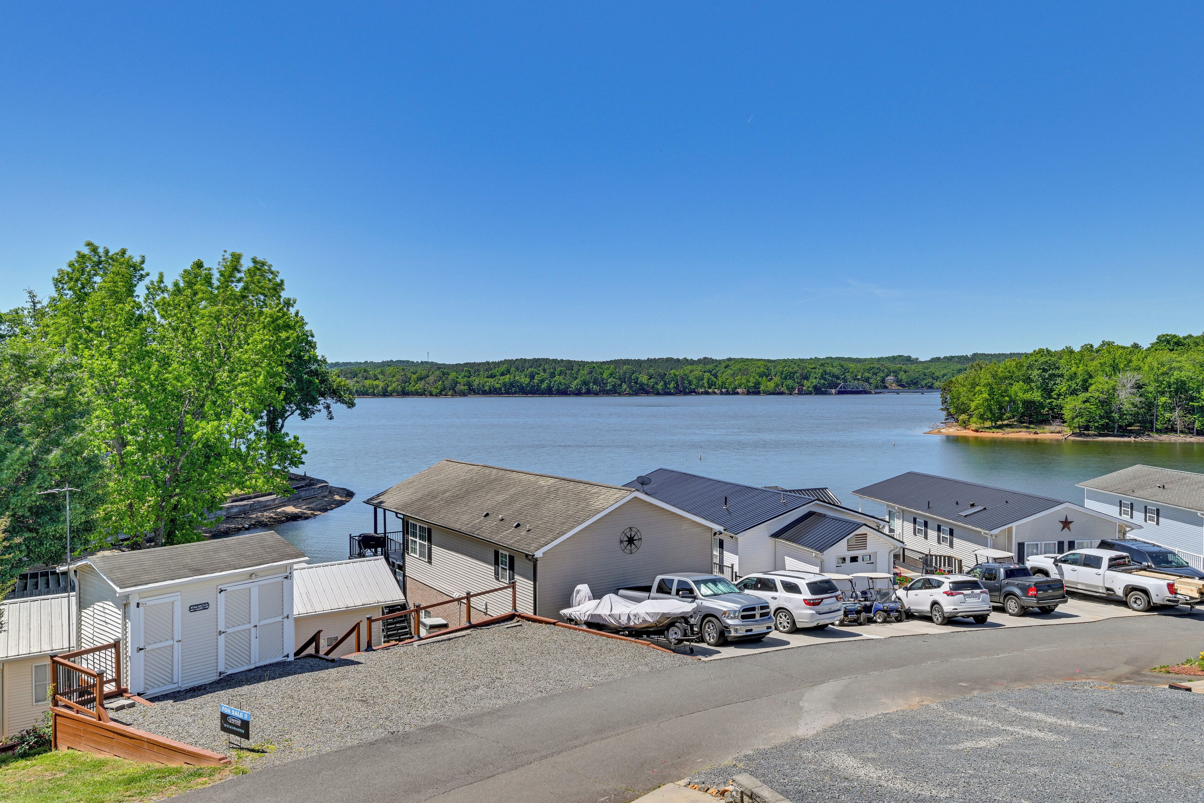 A marina with several boats docked, a covered parking area, and a view of the lake.