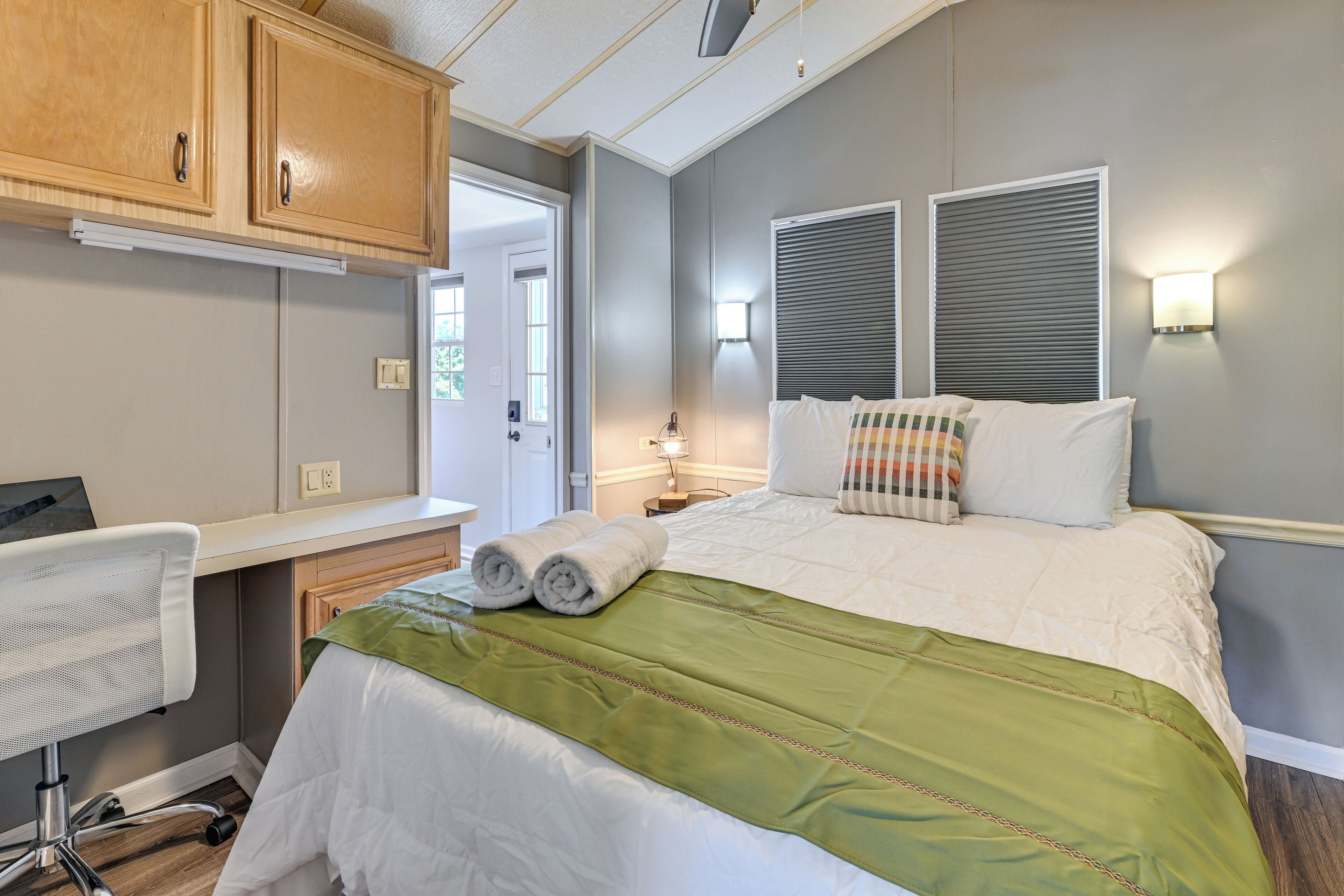 A bedroom with a bed, a desk, and a chair.