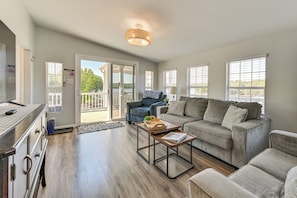 A spacious living room with a sofa, coffee table, and a dining area.