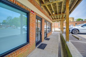 A building with large windows, a covered entrance, and a parking lot.