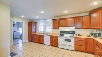 Una cocina con gabinetes de madera, estufa, microondas y lavavajillas.