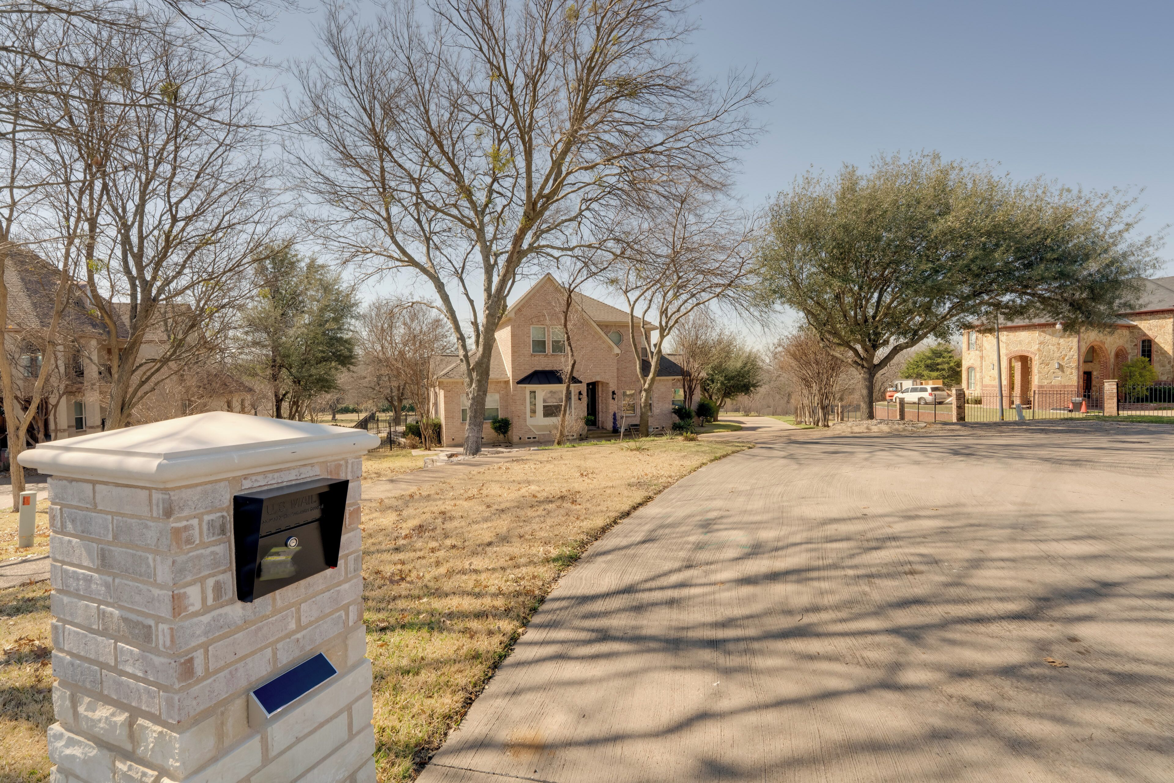 A residential street with houses, a mailbox, and a clear sky.