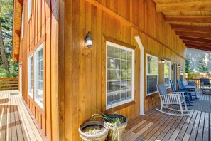 A wooden deck with outdoor seating and potted plants. - Mount Rainier Views & Hot Tub: Pet-friendly Cabin! (Mineral)