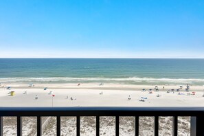 Ein Strand mit Sonnenschirmen, Liegestühlen und einer Flagge.