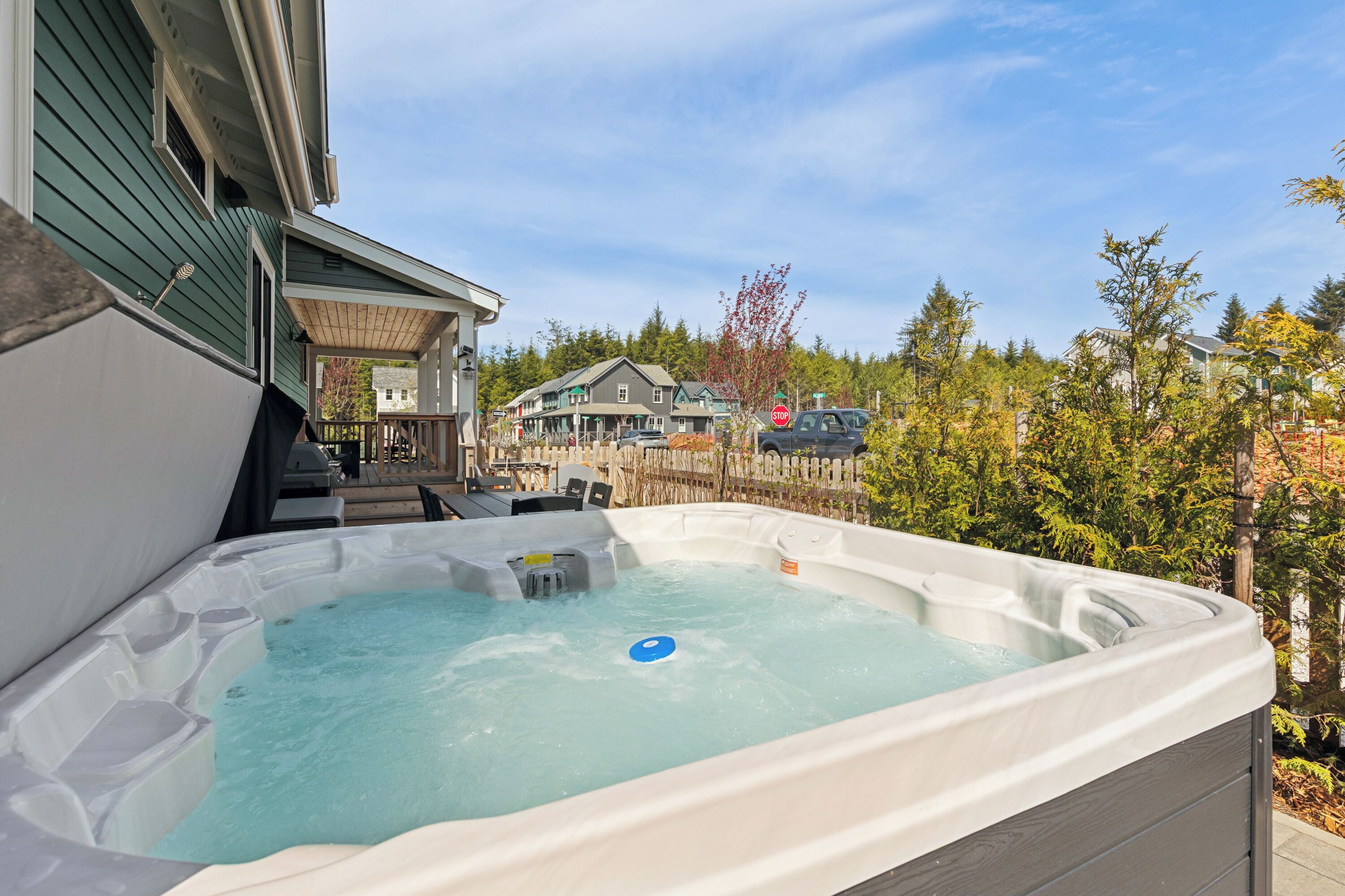 A hot tub with a view of a house and trees.
