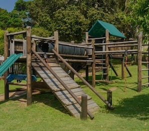 A playground with wooden structures, including a slide and climbing areas.