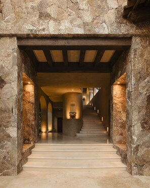 A stone-walled corridor with a staircase leading to a central area. - La Vida Dulce in Punta de Mita (Punta de Mita)
