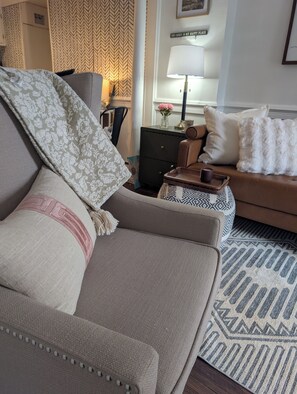 A living room with a sofa, a patterned throw, a small table with a lamp, and a decorative sign on the wall. - Thoughtfully design retreat created for rest, renewal, and meaningful connection (Banner Elk)