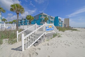A beachfront hotel with a sign reading 'The Beach House at Garden City.'