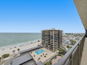 Ein Hochhotel mit Pool, Blick auf den Strand und Stadtpanorama im Hintergrund.