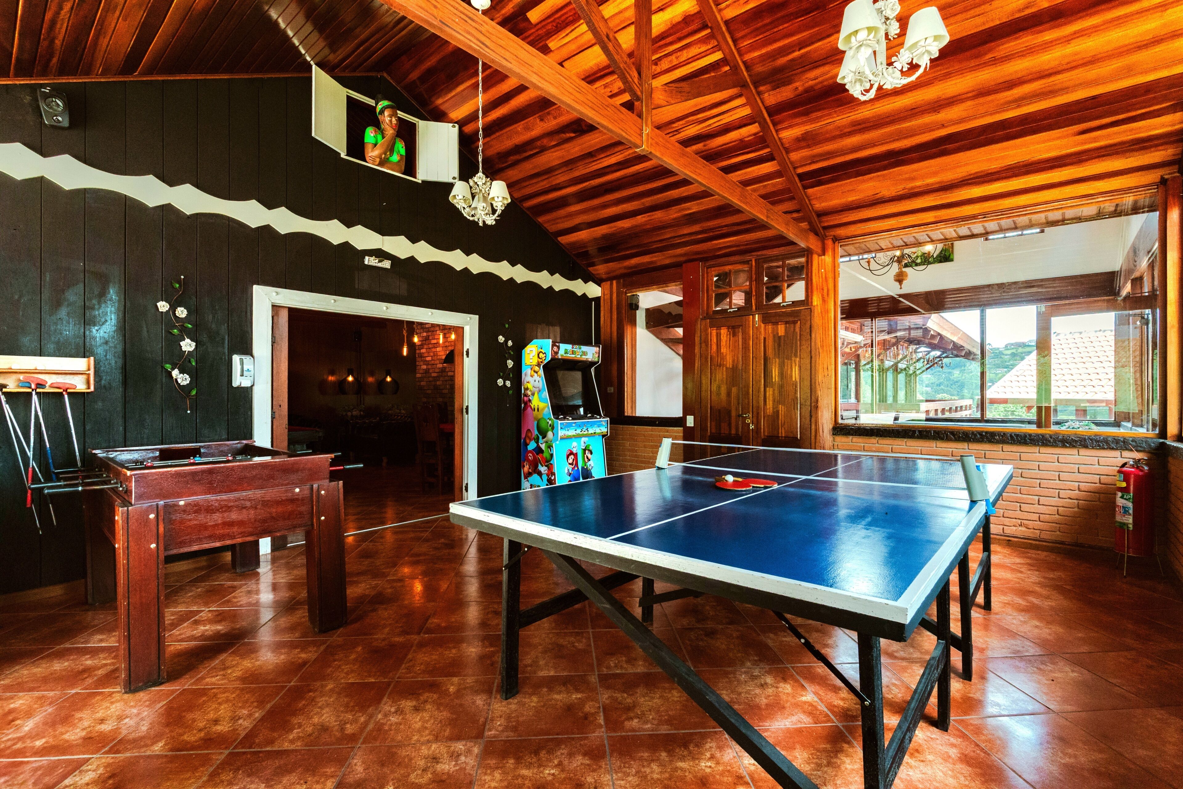 A room with a ping pong table, a foosball table, and a Nintendo 64 gaming console.