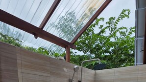 Un baño pequeño y cerrado con inodoro, ducha y paredes de azulejos.