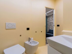 Et moderne badeværelse med toilet, bidet og vask.