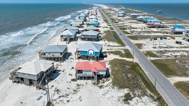 Vista aérea de una zona costera con casas de playa, una carretera y el océano.