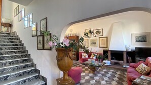 Una escalera conduce a una sala de estar con chimenea, un sofá y una mesita de centro.