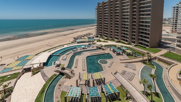 A resort with multiple swimming pools, a beachfront, and high-rise buildings. - Las Palomas Phase II Coronado 801 Exceptional oceanfront 2BR 2BA Unit (Puerto Peñasco)