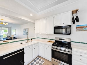 A modern kitchen with white cabinets, a stainless steel stove, and a microwave. - Beautiful single level condo in south Palm Springs (Palm Springs)