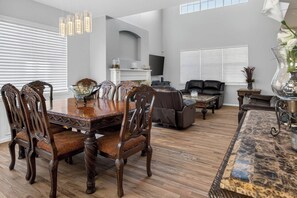 A spacious living room with a dining table, chairs, a sofa, and a fireplace. - 3BR Spacious Home with BBQ Patio,Backyard,Sleeps 6 (Aurora)