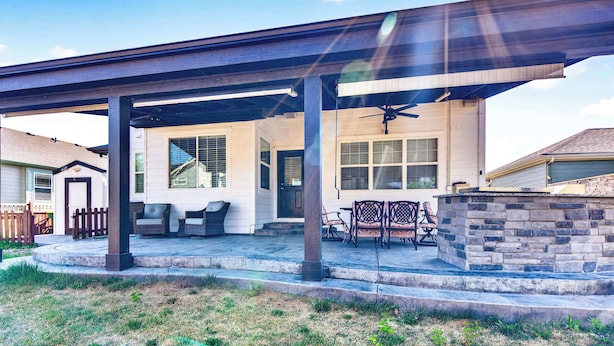 A covered patio with outdoor furniture, a ceiling fan, and a stone wall. - 3BR Spacious Home with BBQ Patio,Backyard,Sleeps 6 (Aurora)