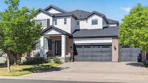 A two-story house with a garage, a covered porch, and a driveway. - 3BR Spacious Home with BBQ Patio,Backyard,Sleeps 6 (Aurora)