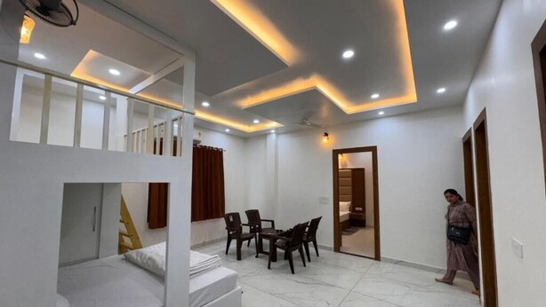 A room with bunk beds, a dining table, chairs, and a ceiling fan. - Hotel Baromas Retreat (Haridwar)