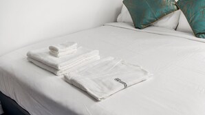 A neatly made bed with white linens and a folded towel on the side. - Executive Double Room ; Boutique Hotel• Trinity Bellwoods. Downtown Toronto (Toronto)
