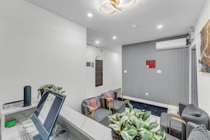 A modern hotel lobby with a reception desk, seating area, and a wall-mounted air conditioning unit. - Plush hotel Downtown Toronto (Toronto)