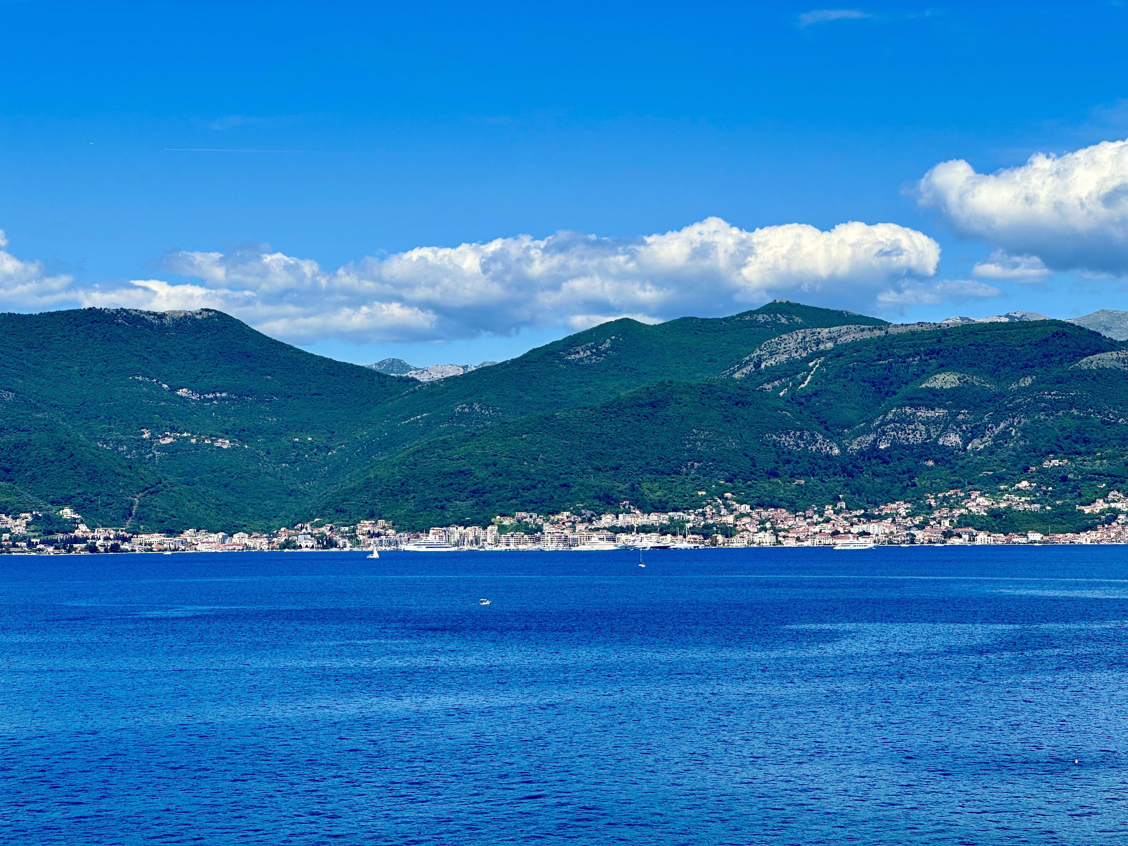 Une ville côtière offrant une vue sur la mer et les montagnes en arrière-plan.