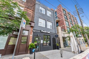 A building with a 'Plush Café' sign, a visible storefront, and a 'No Standing' sign.