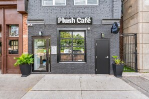 A building with a sign reading 'Plush Café' and a 'Plush Hotel' sign above it.