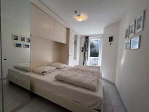 Ein Schlafzimmer mit einem Bett, einem Kleiderschrank und einem Fenster mit Ausblick.