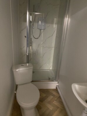 Een aparte badkuip en douche, een diep bad, handdoeken