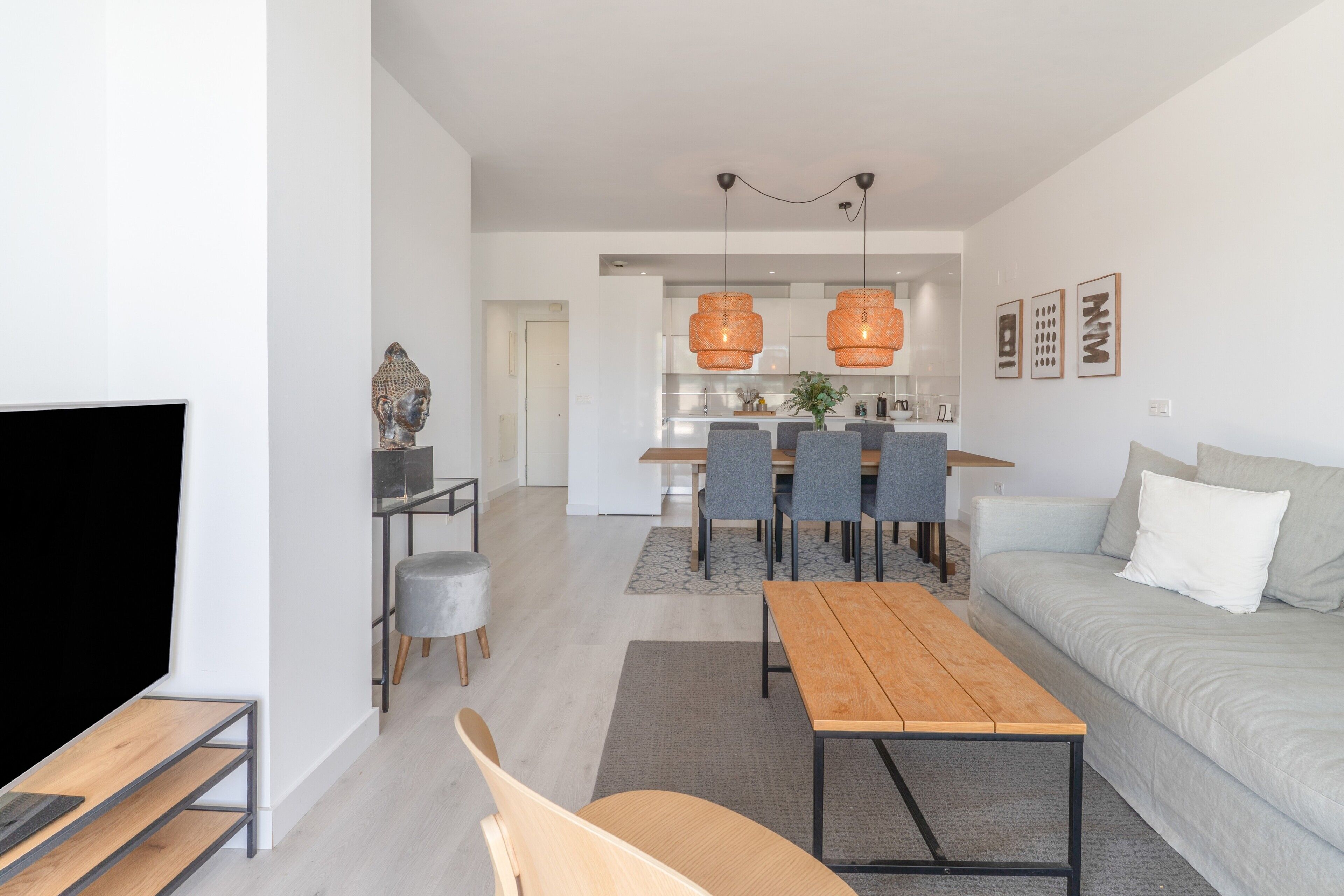 Una sala de estar moderna con un sofá, una mesa de centro de madera y un televisor.