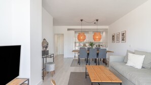 Ein modernes Wohnzimmer mit einer Couch, einem Holztisch und einem Fernseher.