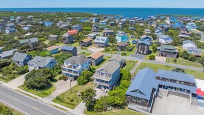 An aerial view of a coastal residential area with houses, a road, and a body of water. - Soundside, Dog Friendly Home in Avon with Hot Tub (Avon)